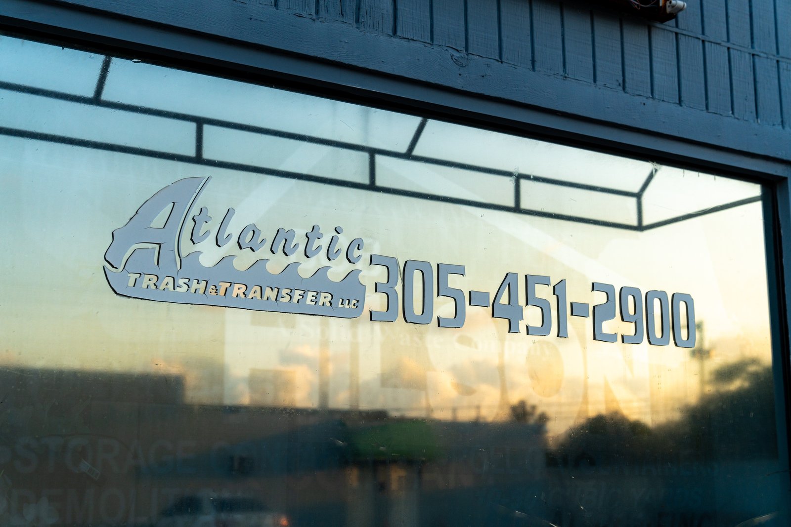 Atlantic Trash & Transfer logo displayed on a company building window.