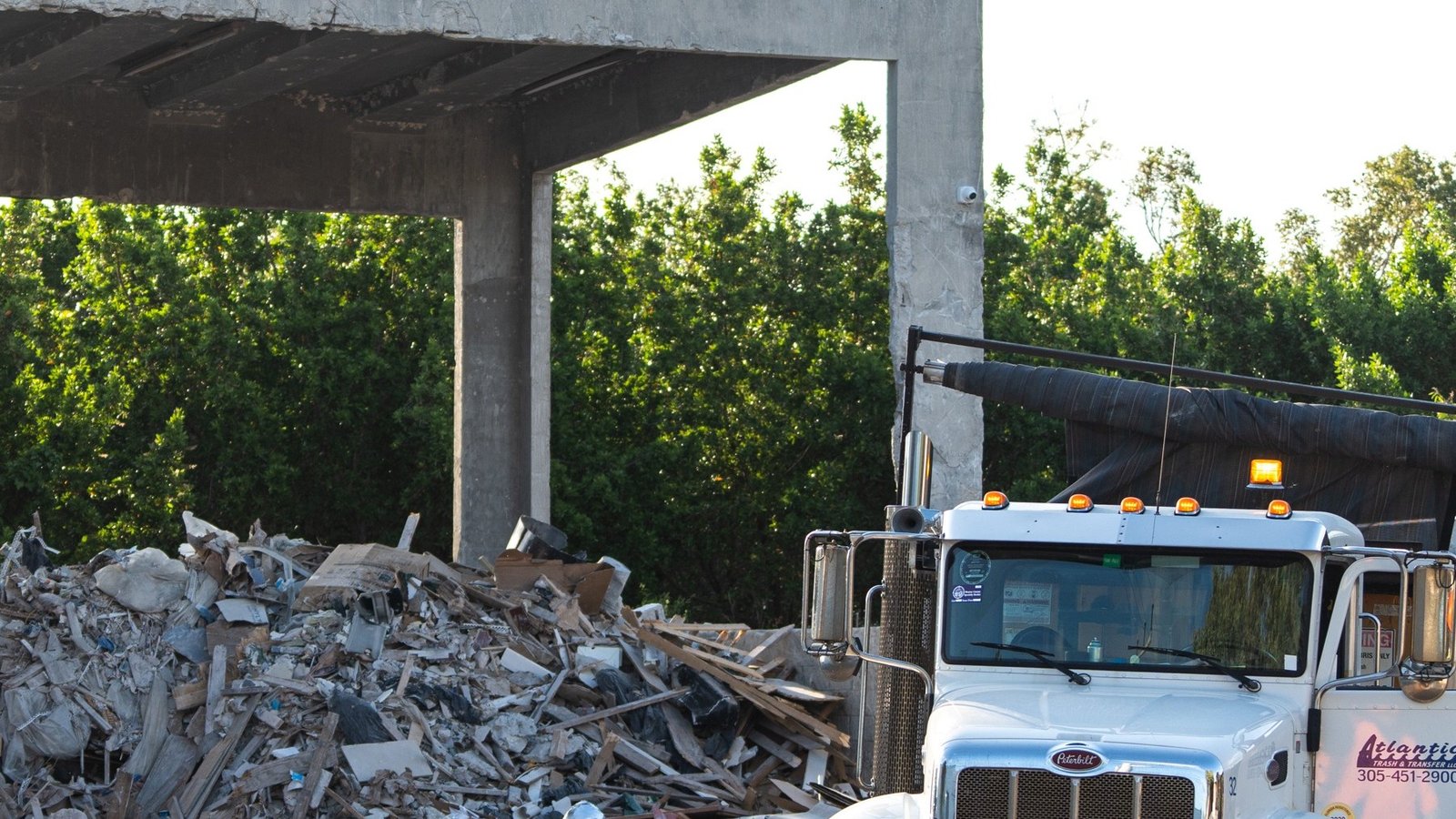 Atlantic Trash & Transfer truck beside the covered transfer-station bay.