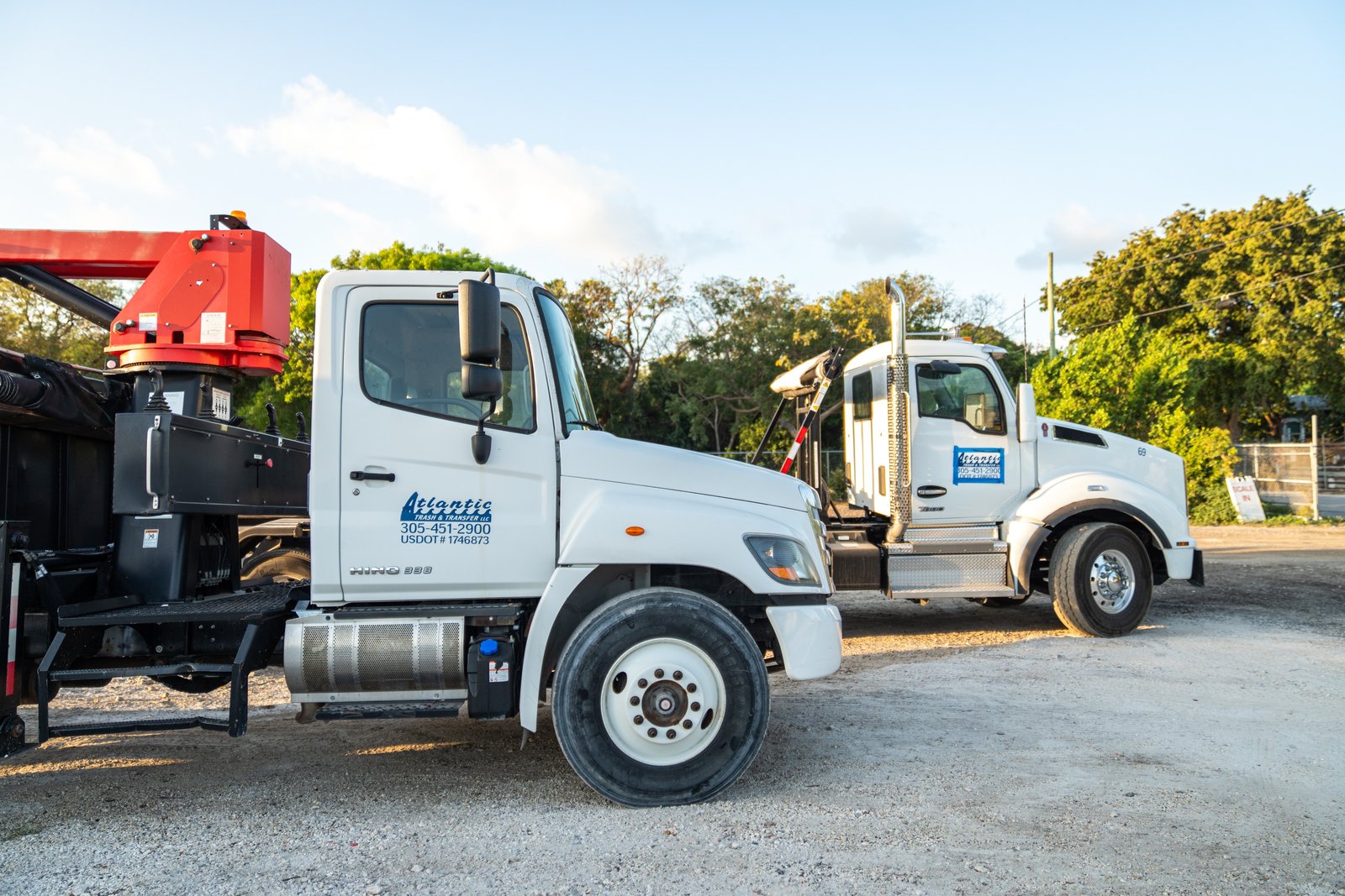 Two Atlantic Trash & Transfer trucks parked at the company yard.